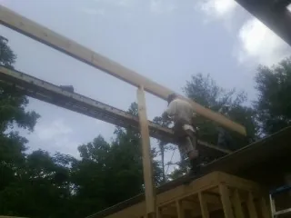 Carpenter setting a ridge beam over a new addition frame — Ice Dam Removal by Roofing Brothers in Raphine